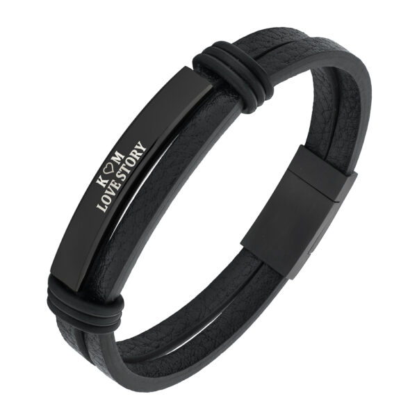 Czarna skórzana bransoletka z metalową blaszką i napisem 'K + M LOVE STORY'.