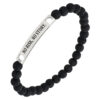 Bransoletka z czarnymi koralikami i metalową blaszką z napisem 'NO RISK, NO STORY.'