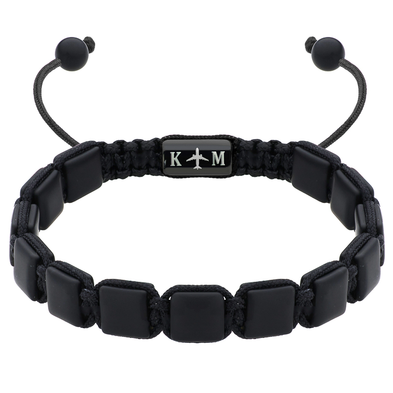 Czarna bransoletka z kwadratowymi koralikami i ozdobnym elementem z samolotem.