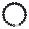 Bransoletka z czarnych koralików z symbolem astrologicznym Raka i jednym jasnym koralikiem.