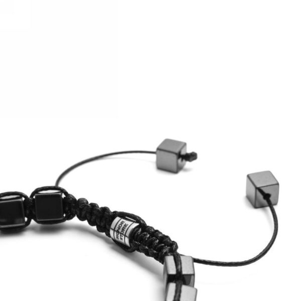 Detale czarnej bransoletki z metalowymi kostkami.