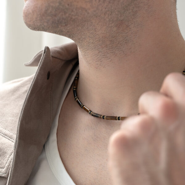 Mężczyzna w naszyjniku z drewnianych koralików.