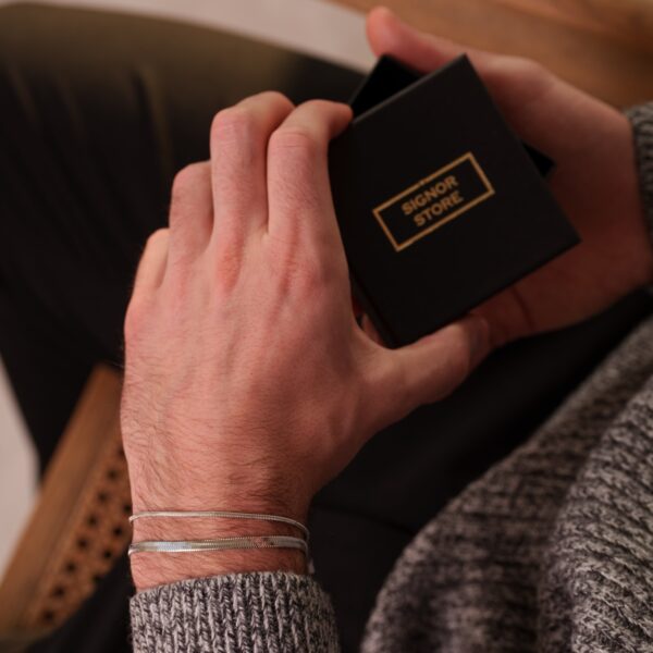 Osoba trzymająca czarne pudełko z napisem Signor Store