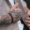 Zbliżenie na wytatuowaną dłoń z bransoletką.
