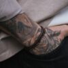 Tatuaż na przedramieniu mężczyzny z bransoletkami