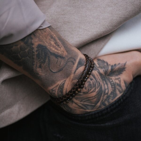 Tatuaż na przedramieniu mężczyzny z bransoletkami