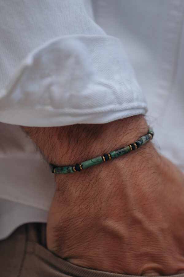Męska ręka z bransoletką z turkusowymi koralikami