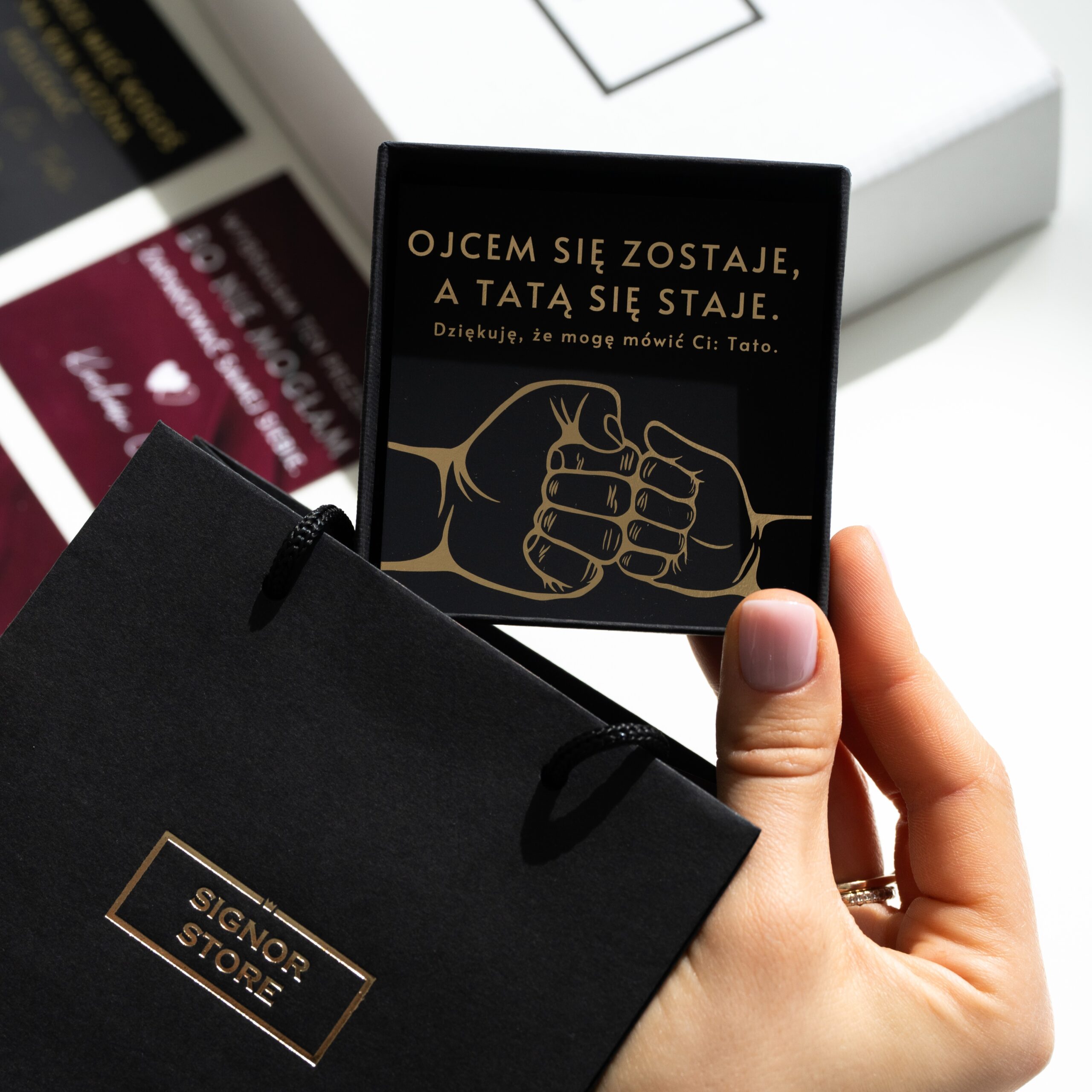 Osoba trzyma tabliczkę z napisem 'Ojcem się zostaje, a tatą się staje. Dziękuję, że mogę mówić Ci: Tato'.