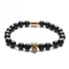 Bransoletka z czarnymi koralikami i złotą czaszką.