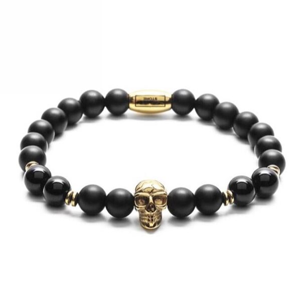Bransoletka z czarnymi koralikami i złotą czaszką.