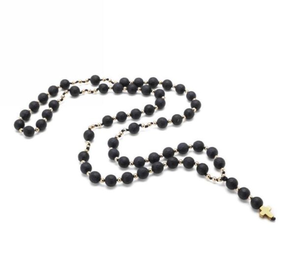 Czarny różaniec z krzyżykiem na białym tle.