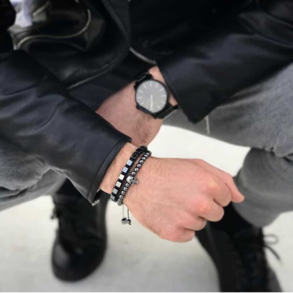 Mężczyzna w skórzanej kurtce, noszący czarny zegarek i bransoletki.
