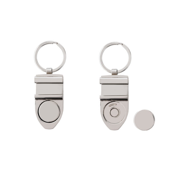 Dwa srebrne breloki z okrągłym wzorem, jeden z odłączonym elementem magnetycznym.