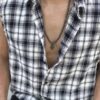 Mężczyzna w rozpiętej koszuli w kratę z naszyjnikiem z krzyżem.