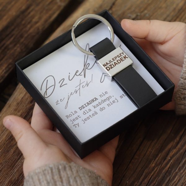 Brelok dla dziadka w pudełku z kartką trzymany w dziecięcych dłoniach