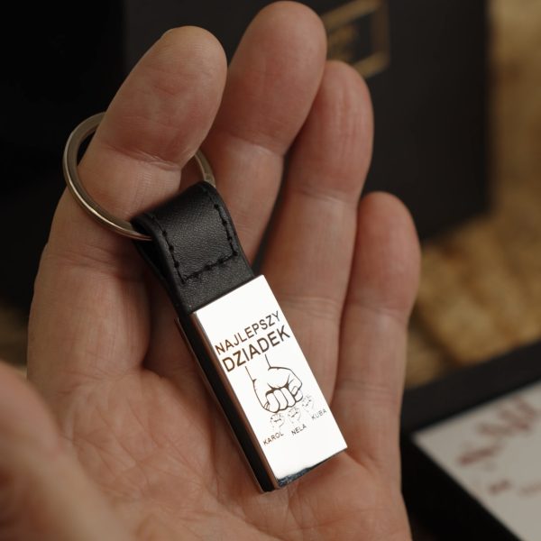 Brelok dla dziadka z grawerem imion wnucząt trzymany w dłoni